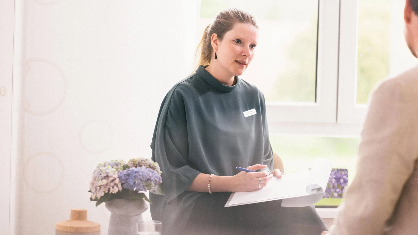 Therapeutin mit notiert im Gespräch auf Klemmbrett