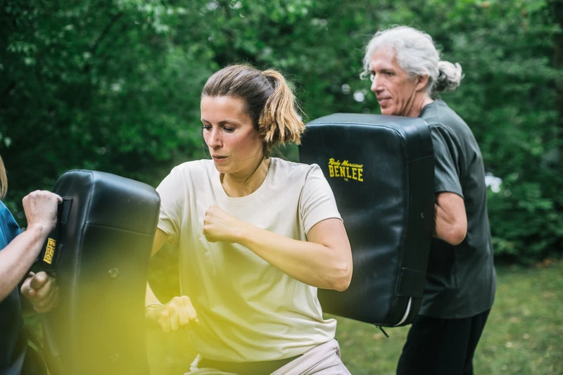 Frau schlägt gegen Box Sack in einer Gruppenübung