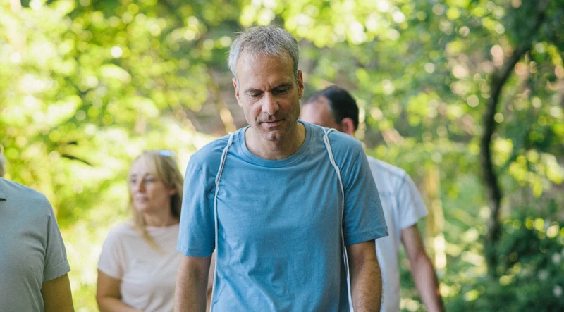 Mann spaziert draußen im wald mit einer gruppe