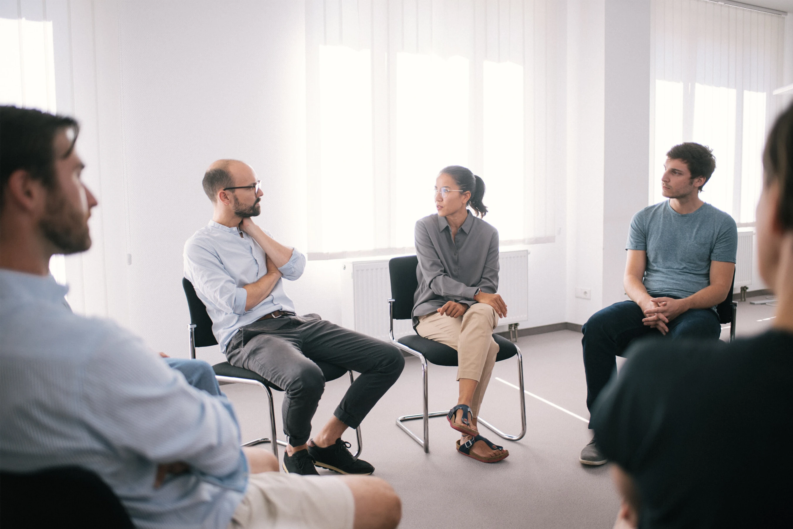 Eine Gruppe von Menschen in einem weißen Therapie Raum