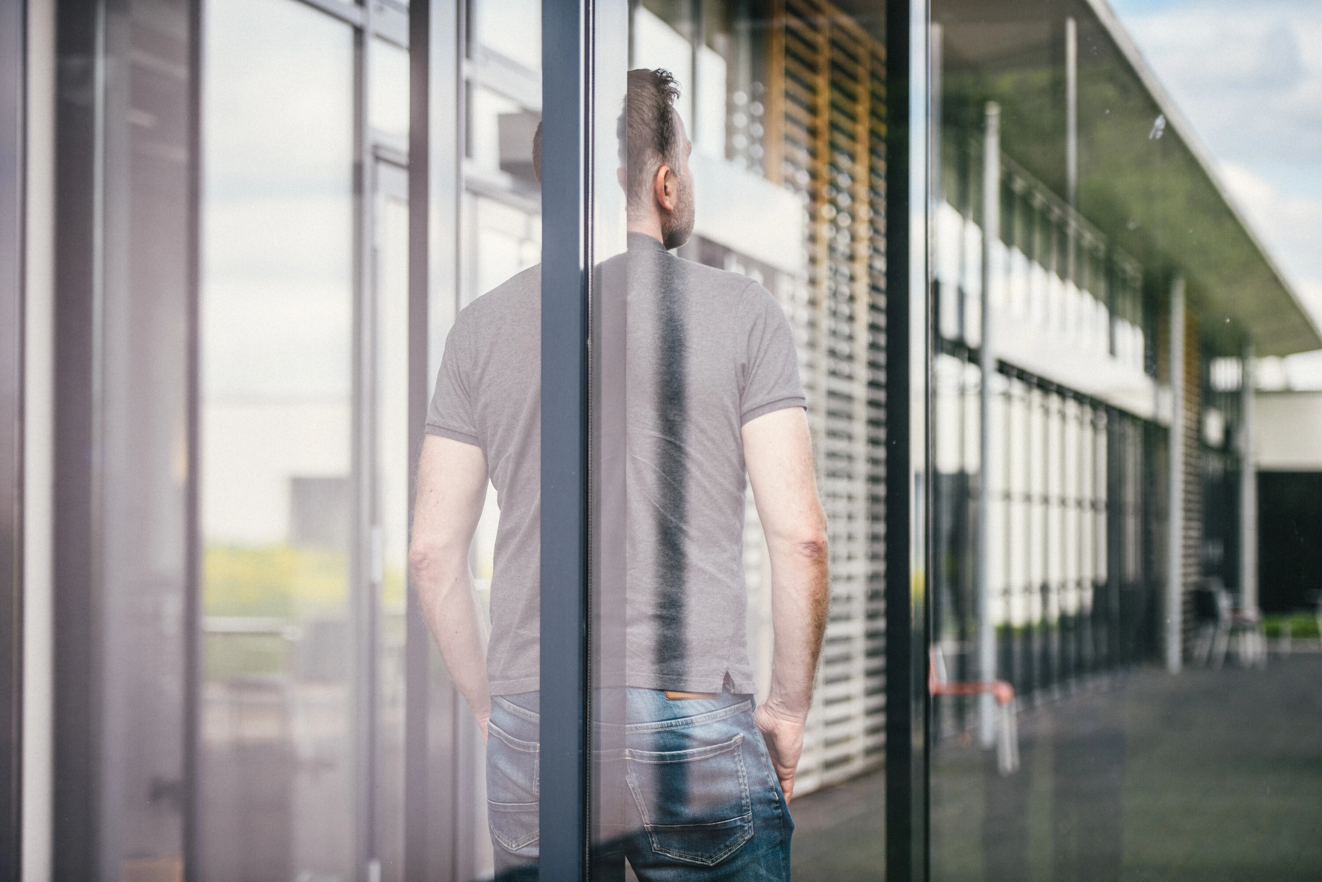 Mann steht mit dem Rücken zum Fenster