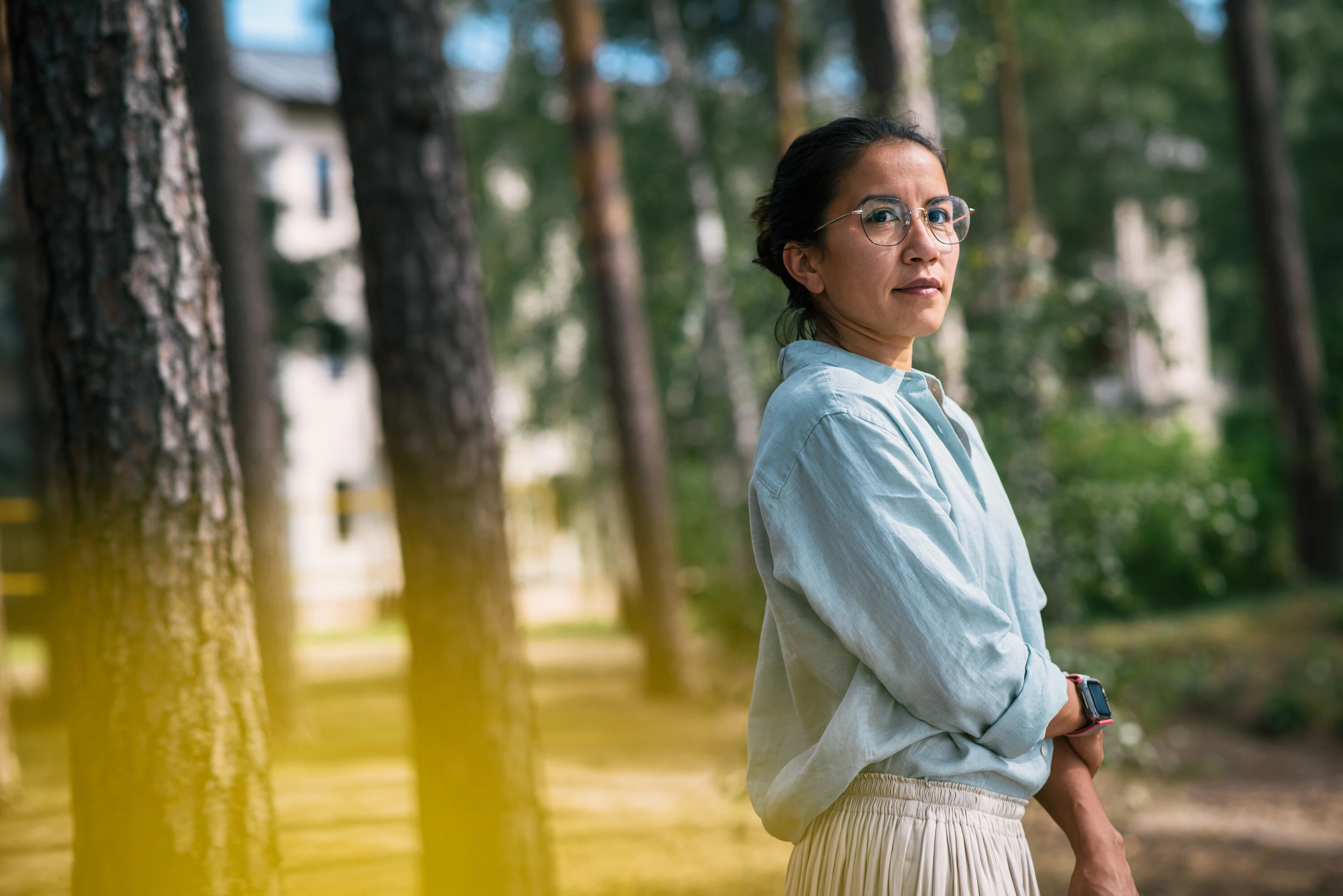 Frau steht draußen und schaut richtung Wald