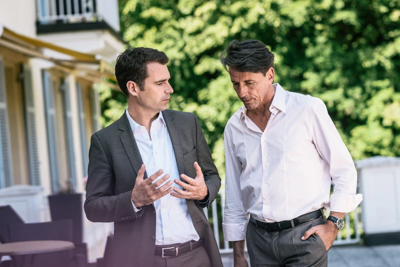 Zwei Männer stehen draußen und reden